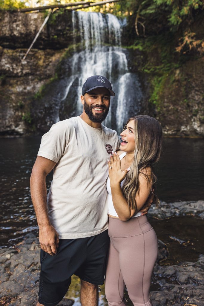 A couple celebrates after a surprise proposal at Silver Falls 